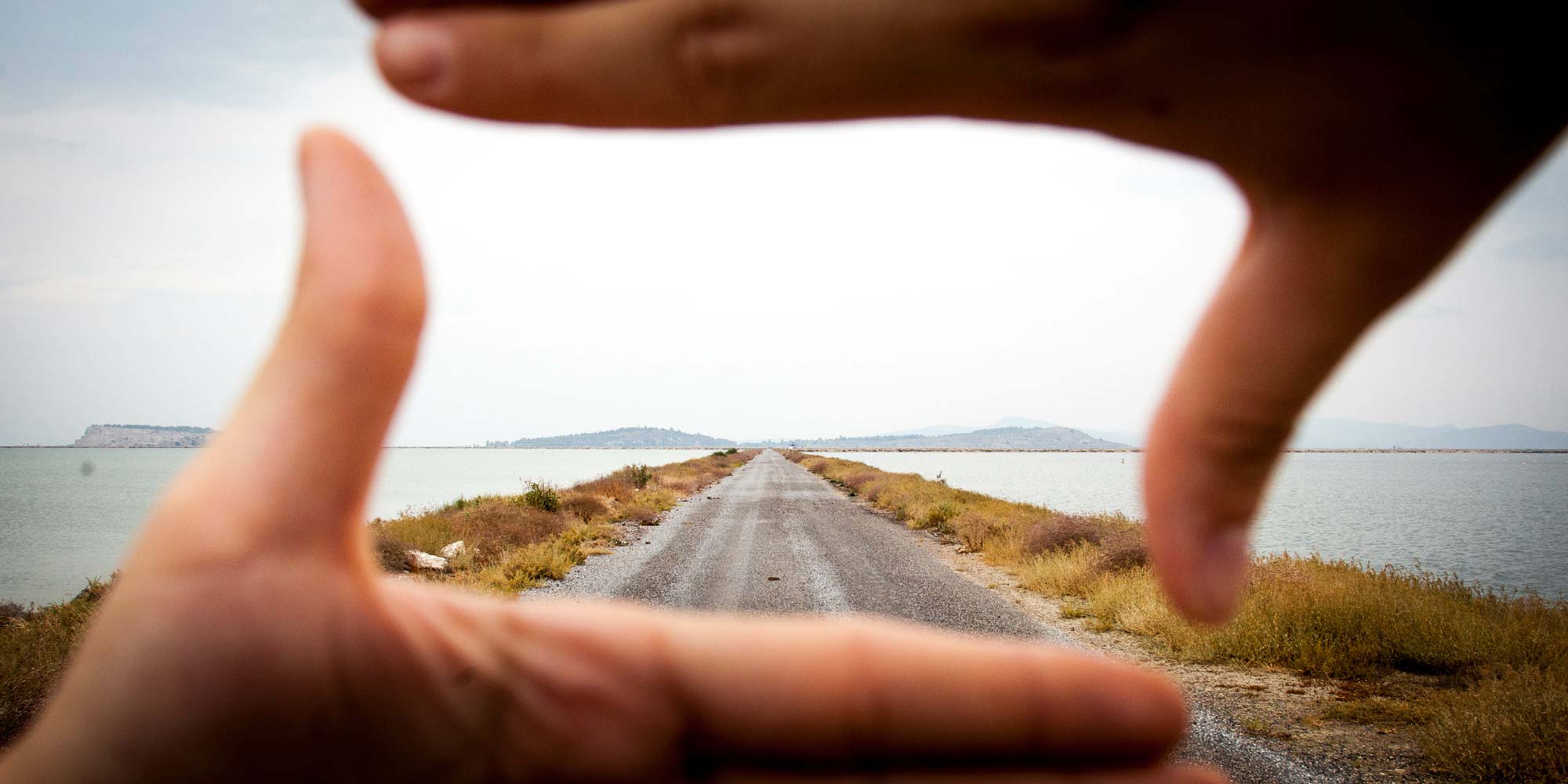 path-on-beach-highlighted-with-hands-in-front-of-camera